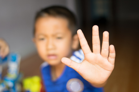 the child reaches out a hand to the cameraの写真素材