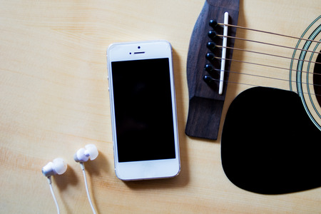 smartphone and headphones on the guitarの写真素材