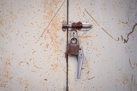 Rusty key on steel doorの写真素材