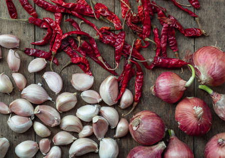 Shallots are placed on brown wooden table background. It's in the bottom right corner of the image and has a copy space in the top left corner. For adding ideas and creativityの写真素材