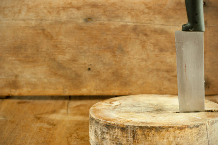 Kitchen knife and cutting board on a wooden table.