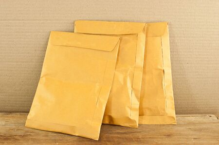 Three envelopes yellow envelope on a wooden table.の写真素材