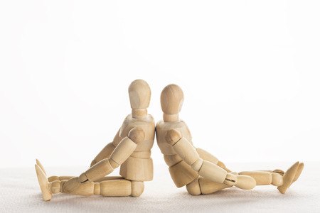 Wood Mannequin Sit Back Facing Each other on isolate white background.の写真素材