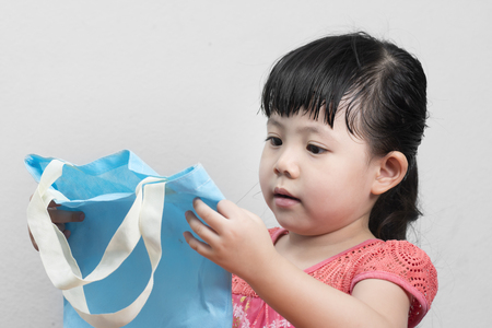 Baby Girl with blue bag for shopping, which can be recycled.の写真素材