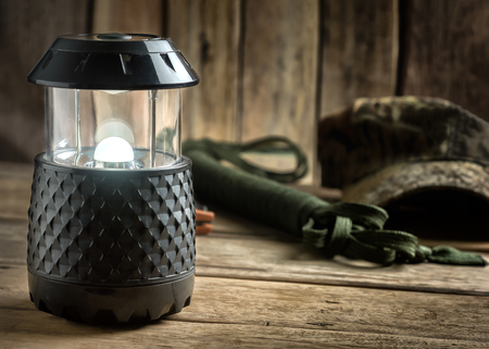 Electric Lamp and Hiking Equipment on Wooden Table.の写真素材