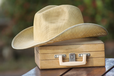 Hat and Wood Luggage on wooden table Equipment needed for summer travel.の写真素材