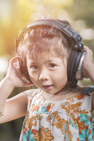 Portrait of an Asian girl wears a headphones smilling in nature garden concept.の写真素材