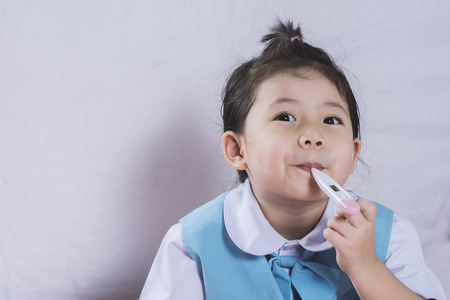 Little AsiaGirl measuring fever with a measuring instrument copy space.の写真素材