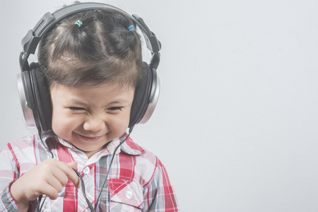 Portrait Asian Girl wear headphones with Long sleeve shirt with red pattern.の写真素材