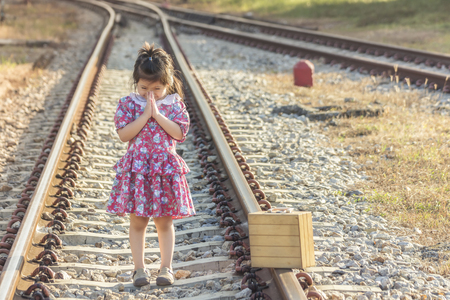 Cute Thai Girl in Red dress costume in a welcome pose, Hello Sawadee on Railroad.の写真素材