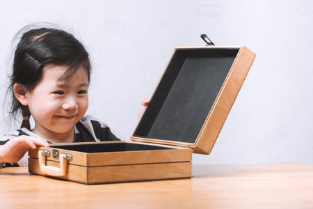Smiling Cute Asian little girl are happy to open a gift bag with space for text.