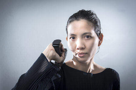 Portraits Aisan woman with a guns in hand. putting a beach on her shoulders. with space for text.の写真素材