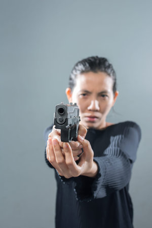 Portraits Serious Asian Woman in position ready to shoot. The eyes look at the target with the...
