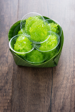 Pandan Flavored Sweet Translucent Gelatinous Rice Recipe. in Banana Leaf on Wooden Table.の写真素材