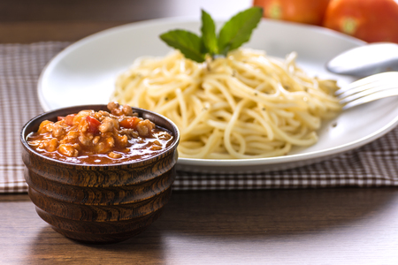  Spaghetti with Pork Tomato Sauce in Wooden Cup And spaghetti on Wooden Table.の写真素材