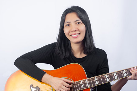 Portrait of Beautiful Asian Women playing Guitars With the intention of practicing. of musical instruments. on Isolate White background, music concept.の写真素材