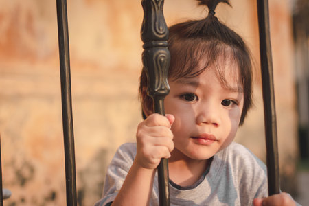 Cute Asian Little Boy hold Ancient stairs thin metal pillarの写真素材