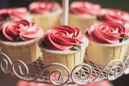Close up Rose Cupcake on heart-shaped shelf At the wedding.の写真素材