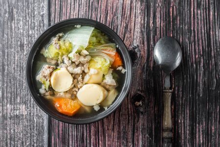 Top View of  Clear Soup with Tofu and Minced Pork in black bowl Ready to serve  Is a healthy food And food for patientsの写真素材