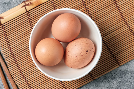 Top Table View of Chicken eggs in a white cup, to prepare for breakfast, nutrition concept.