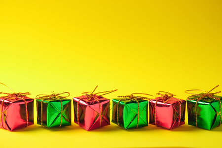 Close-up Festive Red and Green gift boxes on yellow Backgrounds, with space for your text,
