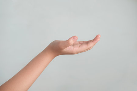 Image of Girl hand with an open palm and fingers on gray background wirh copy space for text.の写真素材