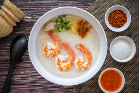 Top Table View of Hot shrimp porridge in a white bowl with condiments, an important food for energy in Asian breakfasts.の写真素材