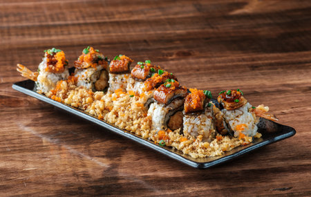 Overloaded Sushi Roll with Tempura Shrimp On a Japanese black ceramic plateの写真素材
