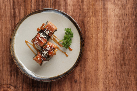 Top View of Unagi Makizushi with Sauce and Sesame Seeds on a Round Plate with copy space for your text.の写真素材