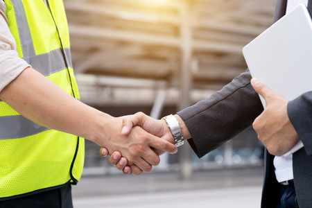 Engineers shake hands with businessman after success day and celebrate success.