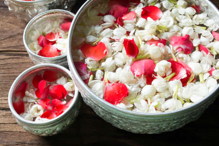 Water in bowl mixed with perfume and flowers corolla for Songkran festival in Thailand.の写真素材