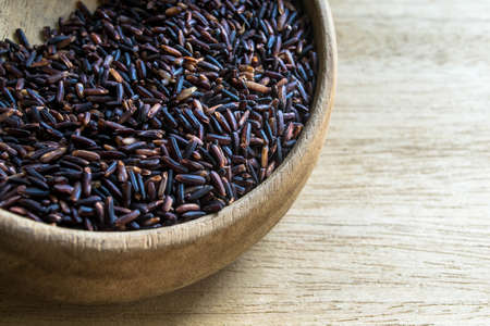 Black rice in wooden bowlの写真素材