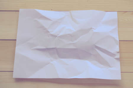 crumpled paper on wooden backgroundの写真素材