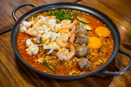 Spicy seafood noodle soup in a potの写真素材