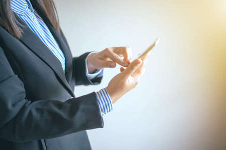 Business woman's hands holding smartphoneの写真素材