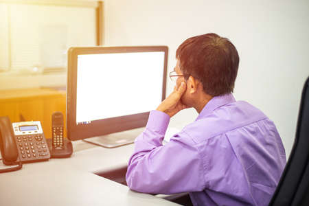 Mature business man sitting in office, thinkingの写真素材