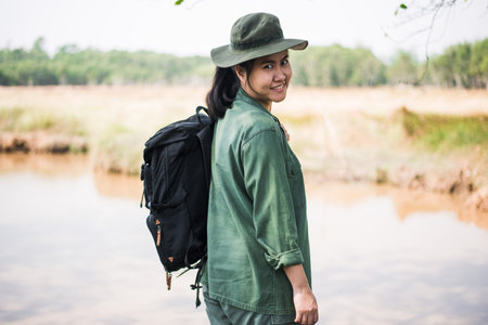Young woman with backpack wild adventure at tropical vacations concept forest and lake