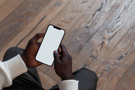 Smartphone blank white screen in hands dark skin. Generative AI.の素材