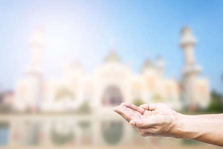 Human hands pray and mosque background.の写真素材