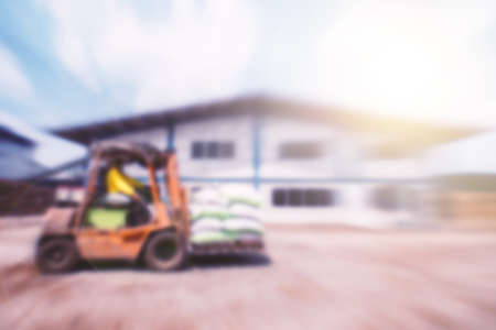 Blurred worker driving a forklift through a warehouse.の写真素材