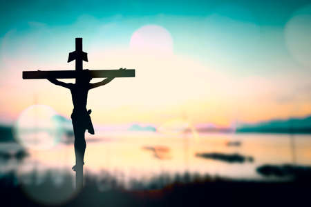 Silhouette of Jesus with Cross over sunset concept for religion, worship, prayer and praise.の写真素材