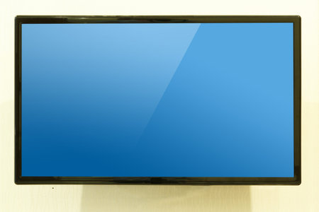 Modern LED Television hang on wall with blue screenの写真素材