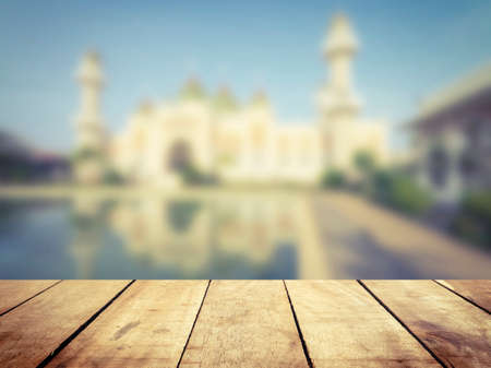 Wooden board table  in front of blurred pattani public mosque background. concept for islam, allah, ramadan, pray, muslim, hope, faith, war, holy.の写真素材