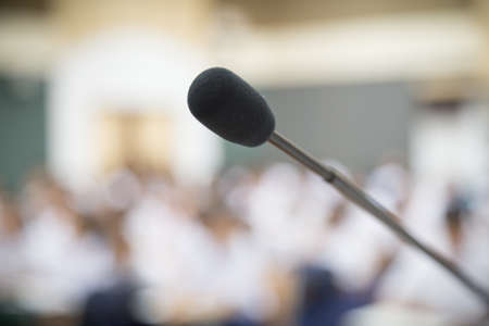 Close up Microphone selective focus over the blurred photo of conference hall or seminar room background.の写真素材