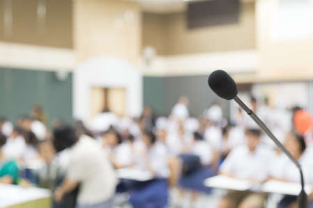 Close up Microphone selective focus over the blurred photo of conference hall or seminar room background.の写真素材