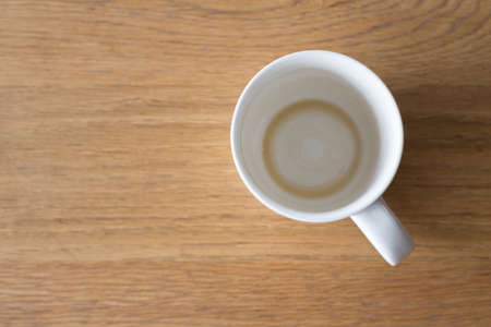 Closeup one coffee cup of hot black cappuccino on clean wooden table in morning light. space for text design. Aroma love caffeine smell.の写真素材