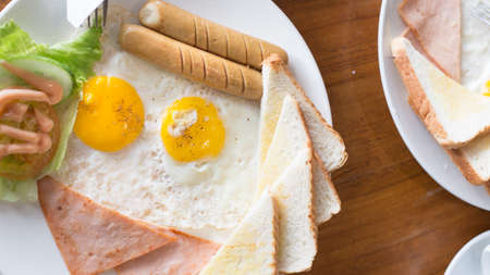 English breakfast background. Closeup fried eggs, hot beans salad cream and delicious toast serve directly in every morning.の写真素材