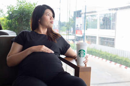 Hatyai ,Thailand-August 05 : Young beautiful woman pregnant with Starbucks Hot beverage coffee on hand on 05 August 2017 at Central Festival, Hatyai, Thailand.のeditorial素材
