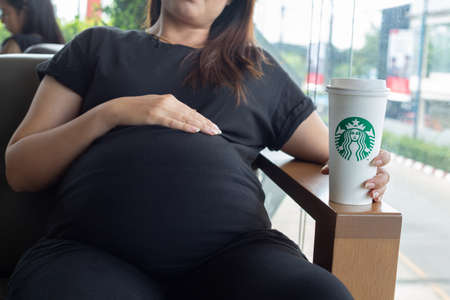 Hatyai ,Thailand-August 05 : Young beautiful woman pregnant with Starbucks Hot beverage coffee on hand on 05 August 2017 at Central Festival, Hatyai, Thailand.のeditorial素材