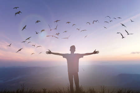 Happy man rise hand on morning view. Christian inspire praise God on good friday background. Now one man self confidence on peak open arms enjoying nature the sun concept world wisdom fun hopeの写真素材